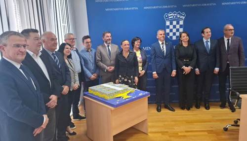 A group of people standing in front of a table

AI-generated content may be incorrect.